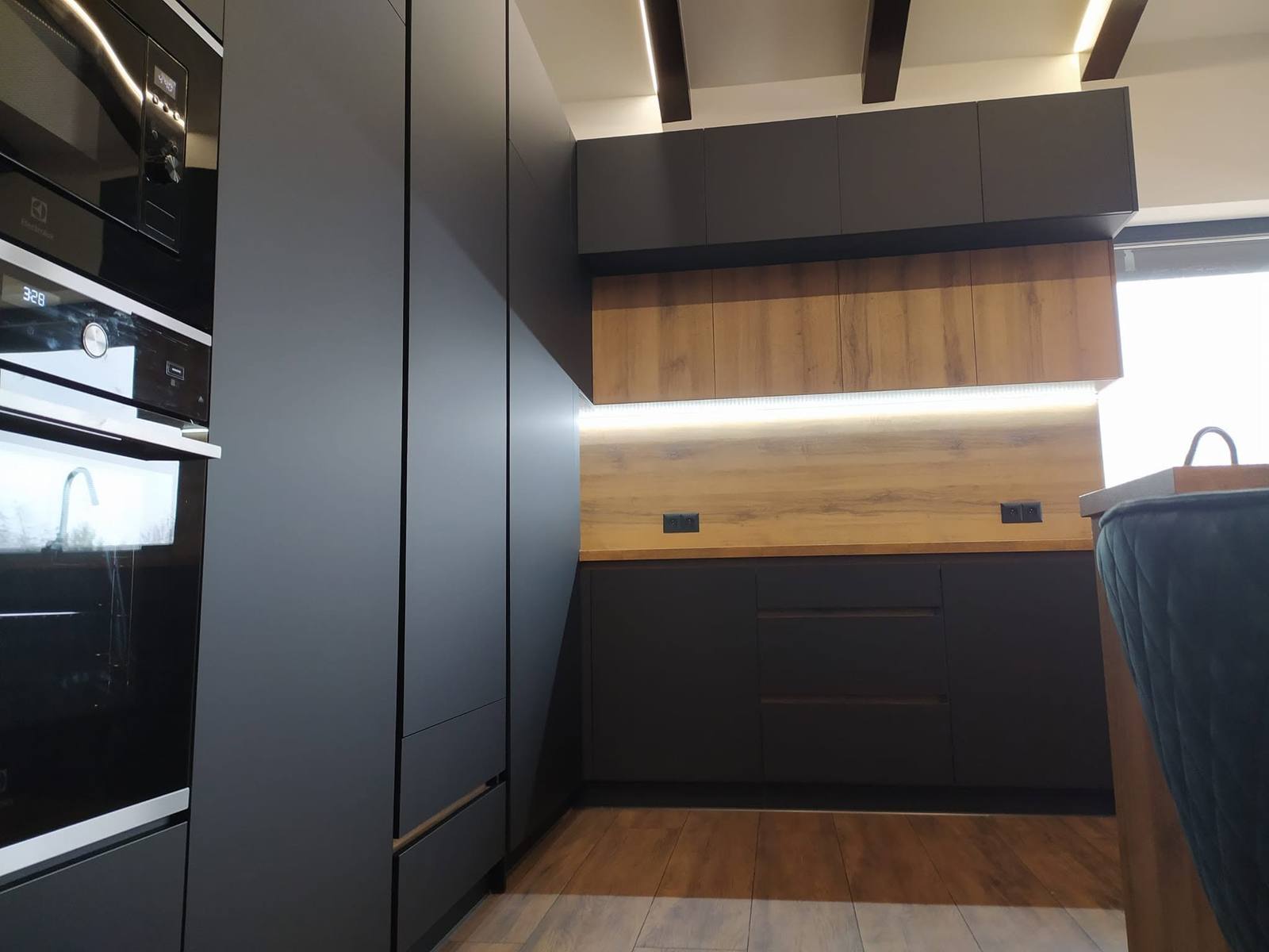 Detail des Anthrazit-Blocks mit Nussbaumregal und LED-Beleuchtung.