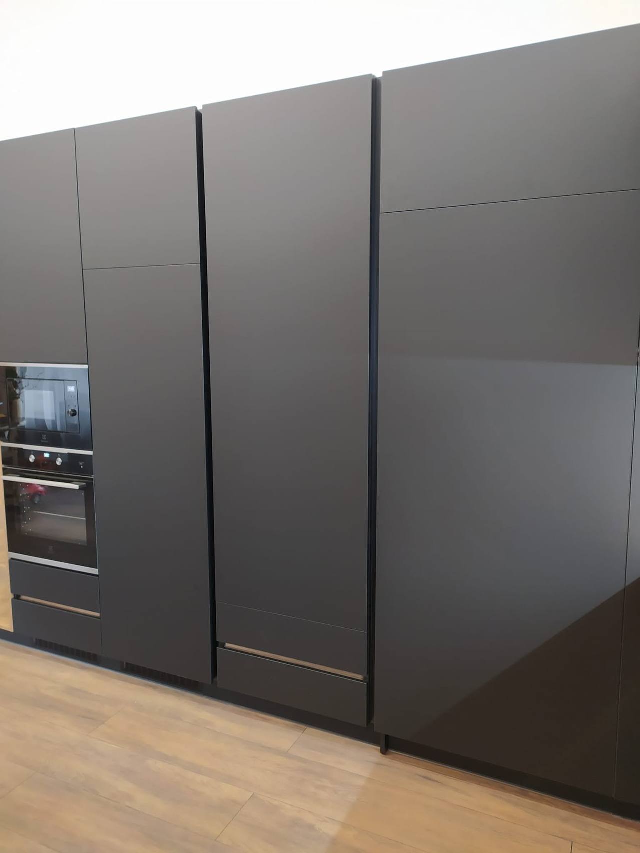 Anthrazitfarbener grifflose Hochschrank mit Einbaugeräten.