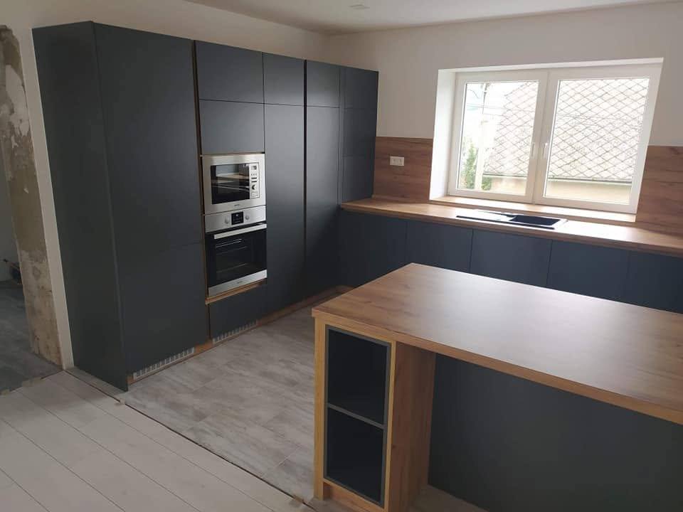 Anthrazitfarbener Hochschrank und Eichen-Halbinsel in der Küchenecke.