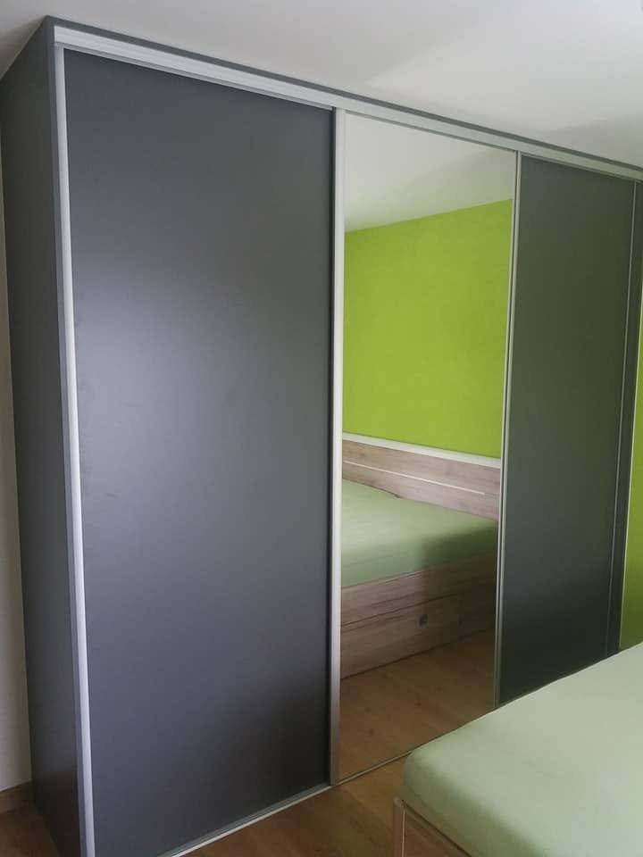 Schrägansicht der Anthrazit- und Spiegeltür neben dem Bett
