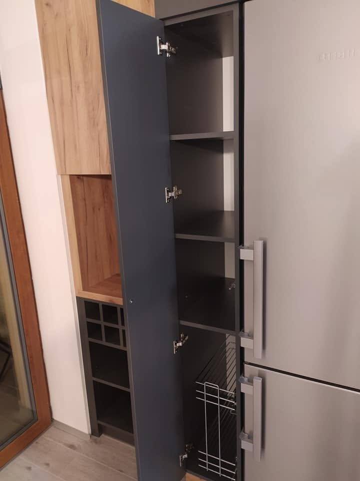 Auszugsspeise mit geöffneter Tür im anthrazitfarbenen Hochschrank.