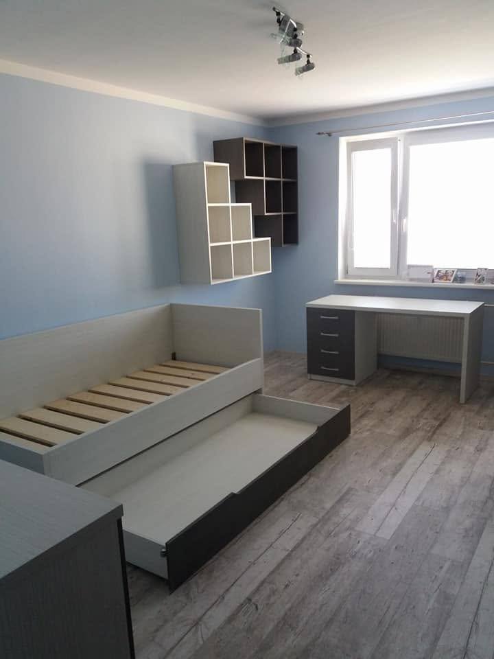 Bett mit seitlichem Auszug am Fenster im blauen Zimmer