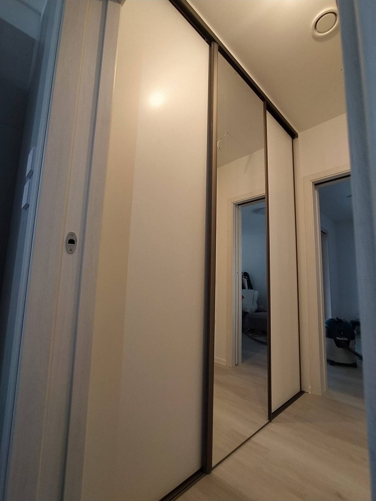 Béžová posuvná skriňa so zrkadlovými dverami a čiernymi rámami