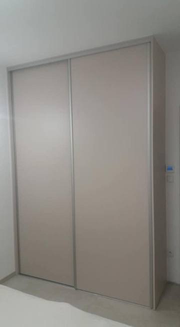 Beiger Einbaukasten mit zwei schlichten Schiebetüren.