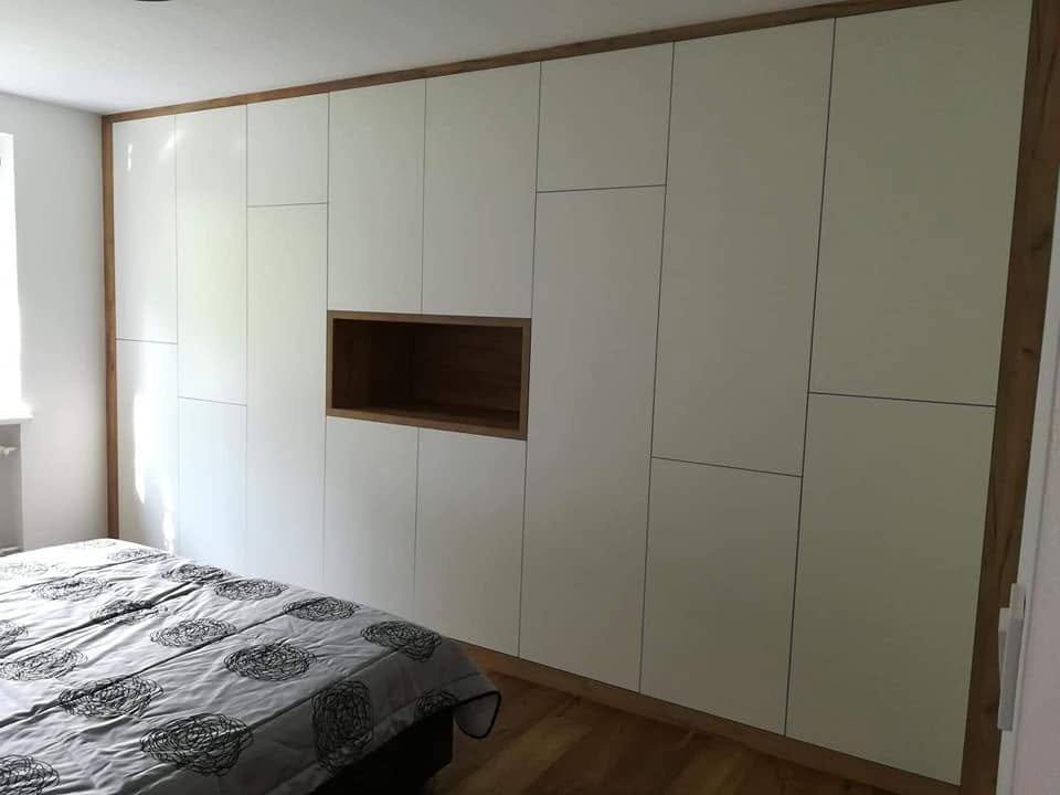 Kastenwand mit Eiche-Nische über dem Bett am Fenster.