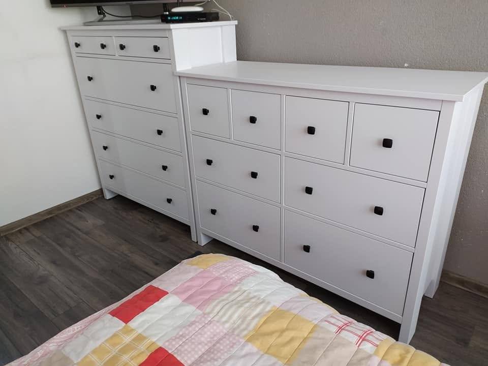 Weiße Kommode mit mehreren Laden und schwarzen Knöpfen