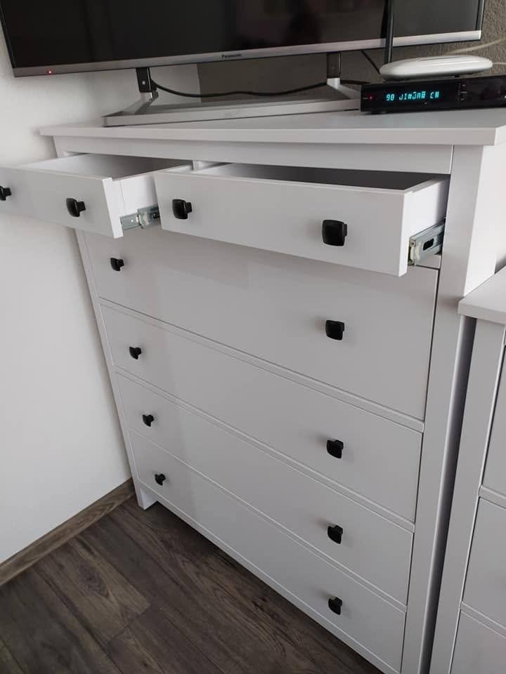 Geöffnete Lade der weißen Kommode mit schwarzem Knopf