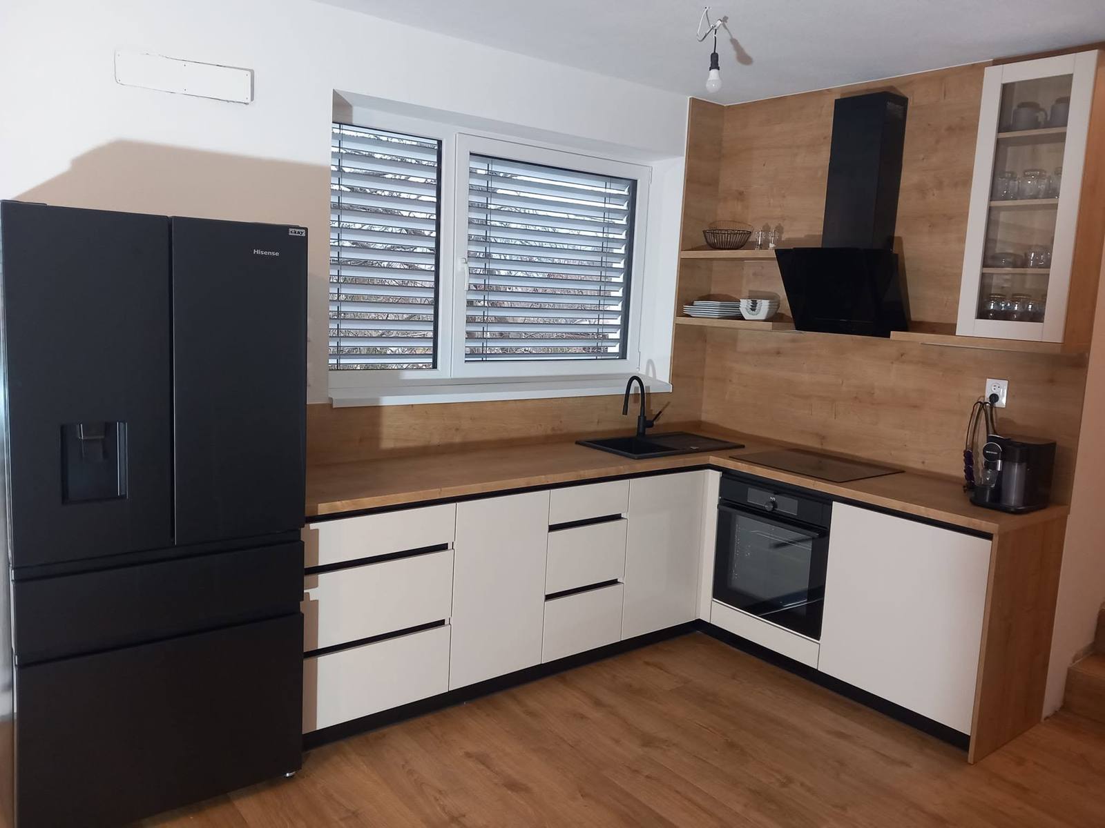 Eckzeile mit schwarzem Dunstabzug und Vitrine am Ende
