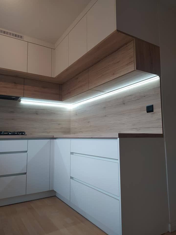 Ecke der weißen Küche mit LED-Band unter den Oberkästen