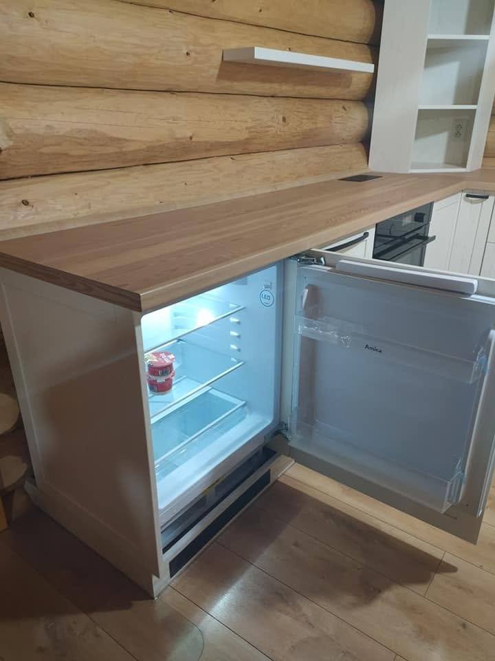 Unterbaukühlschrank mit geöffneter Tür in der Holzküche.