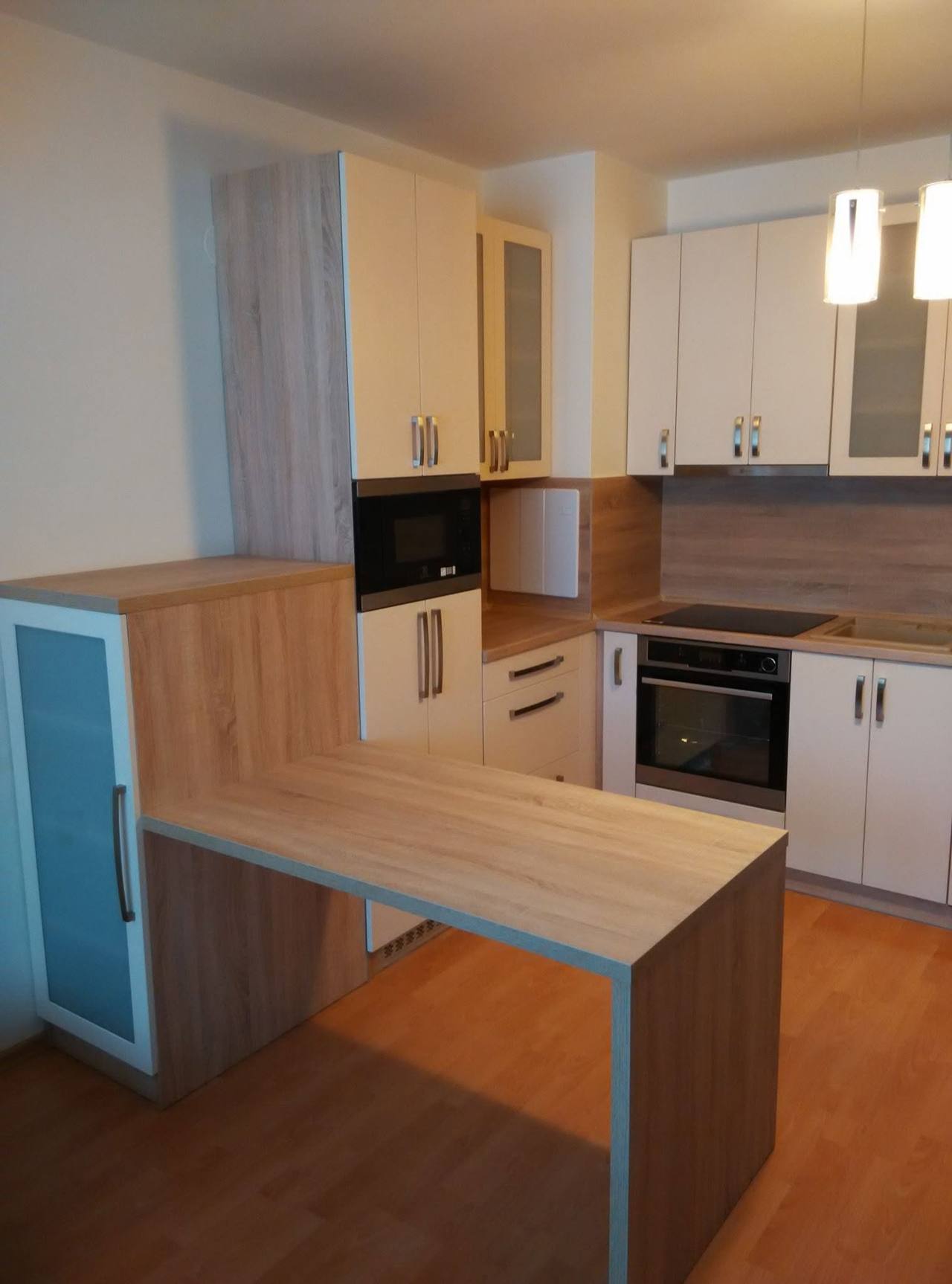 Weiße Küche mit Eichen-Bartisch und Rückwand in Holzdekor