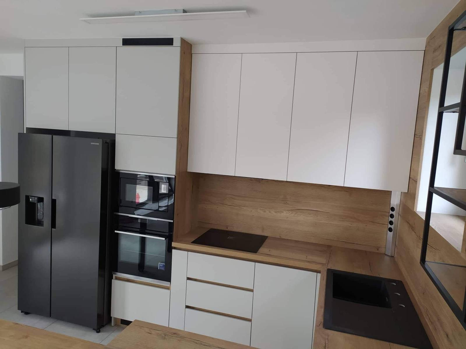 Weiße Küche mit Eichendekor und schwarzem Side-by-Side-Kühlschrank