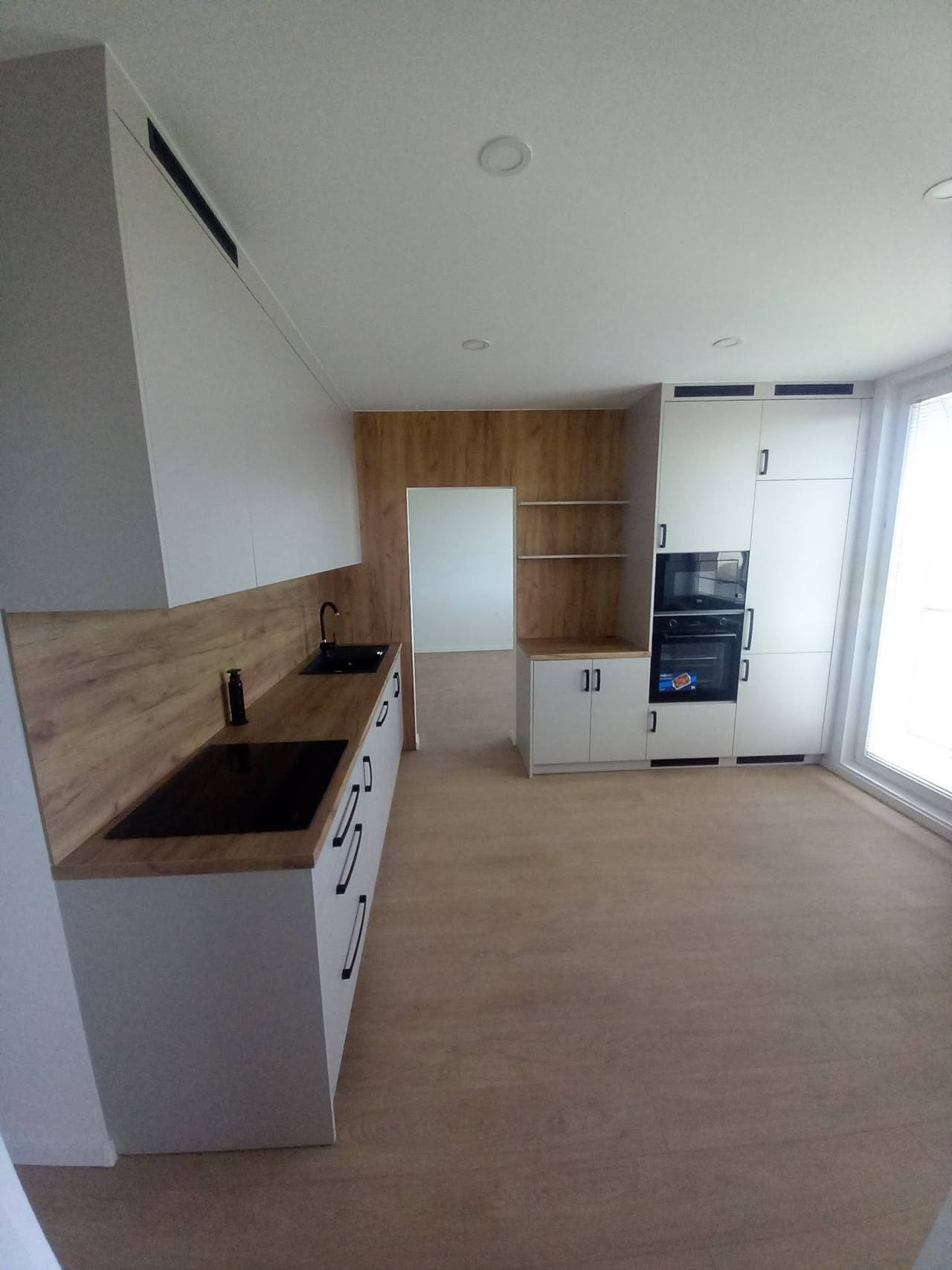 Blick entlang der weißen Zeile zur Eichenwand mit Tür