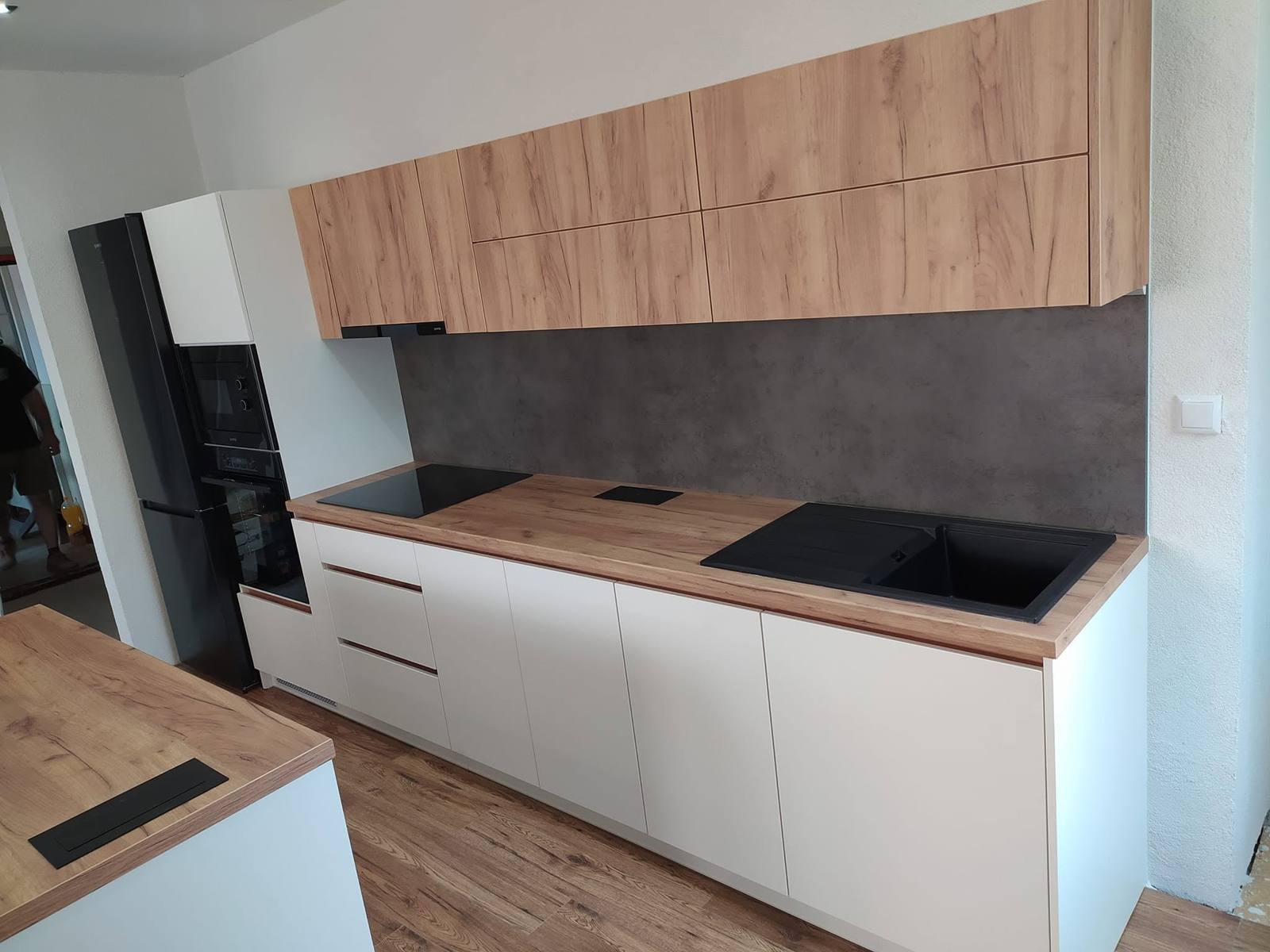 Weiße Zeile mit Eichen-Oberkästen und grauer Beton-Rückwand
