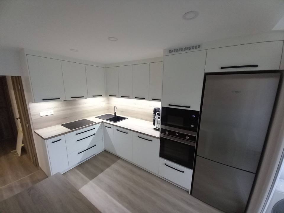 Weiße Küche mit offenem Regal und Edelstahlkühlschrank