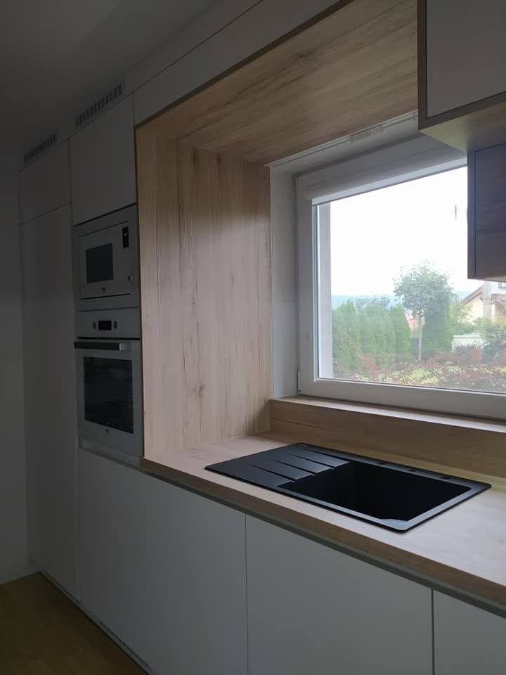 Weiße Küche mit Fenster im Eichenrahmen und schwarzer Spüle