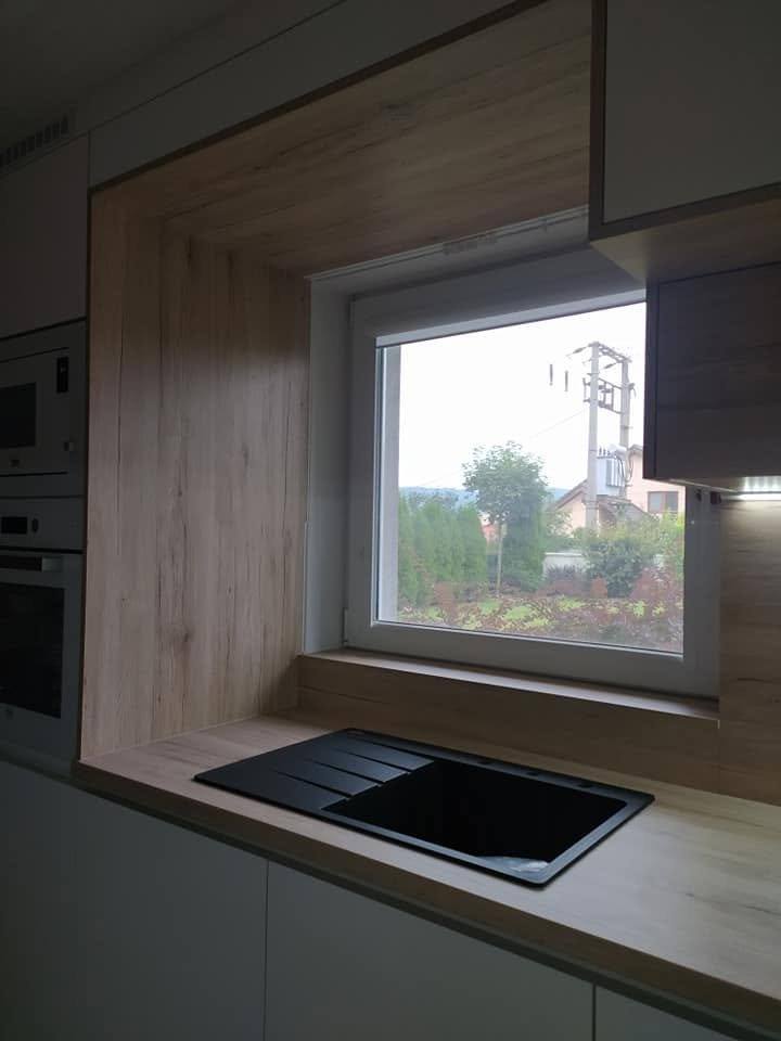 Fensternische in Eichenoptik über schwarzer Spüle mit Abtropffläche