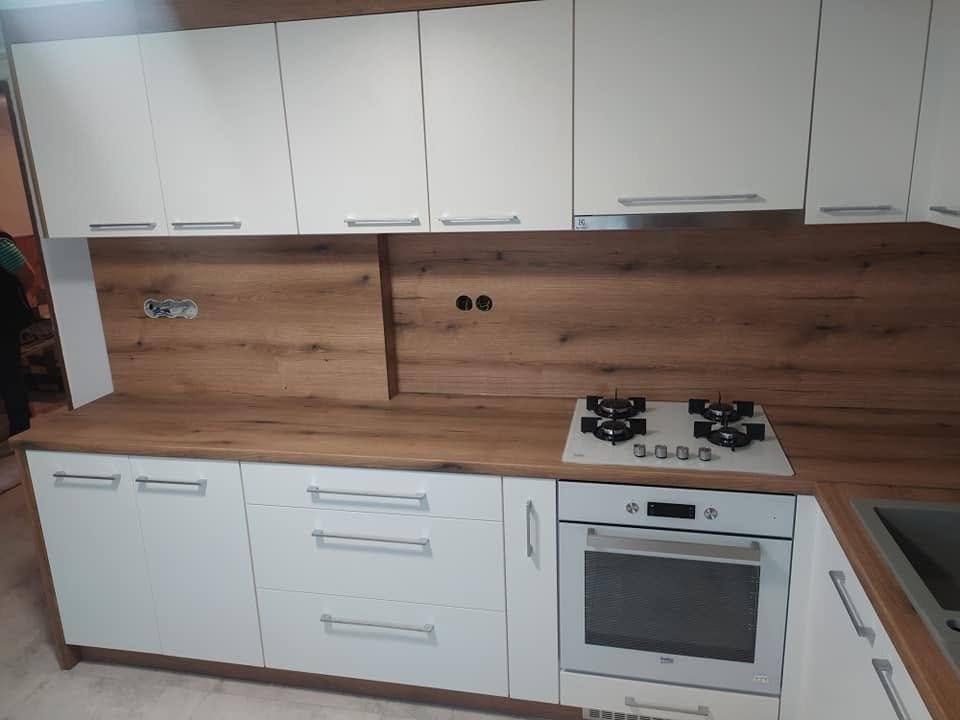Weiße Küche mit Nussbaum-Rückwand und freistehendem Gasherd