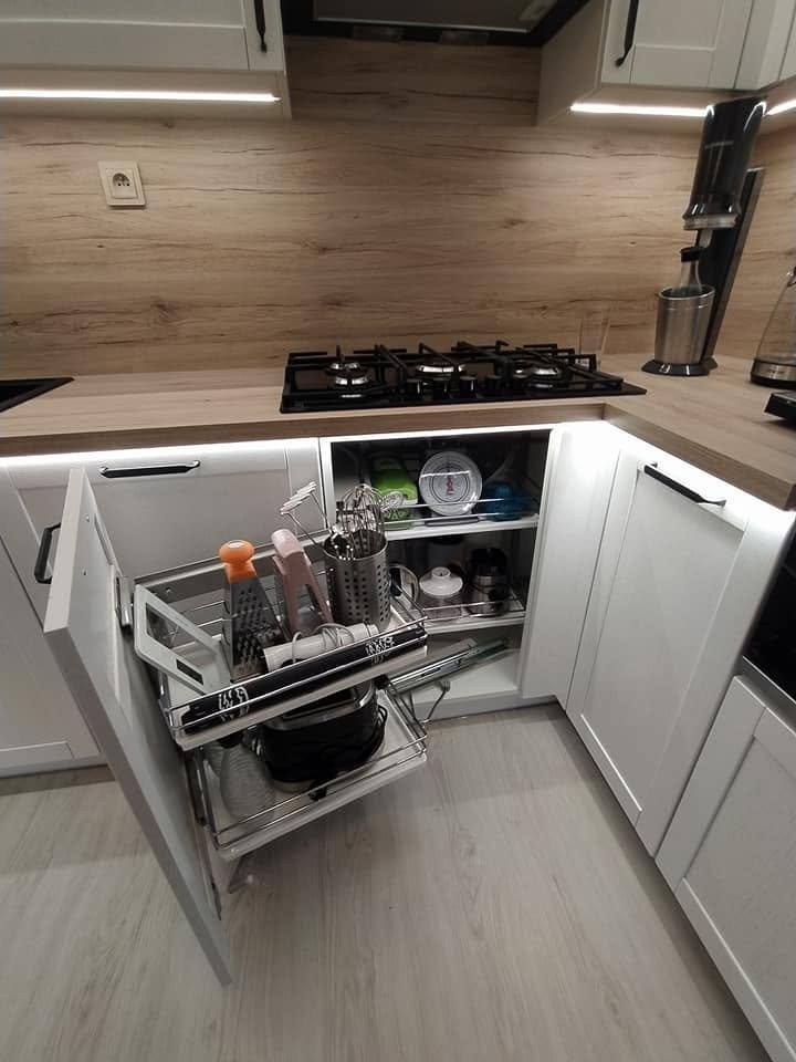 Eckauszug mit drehbaren Böden in der weißen Küche mit Eichenspiegel.