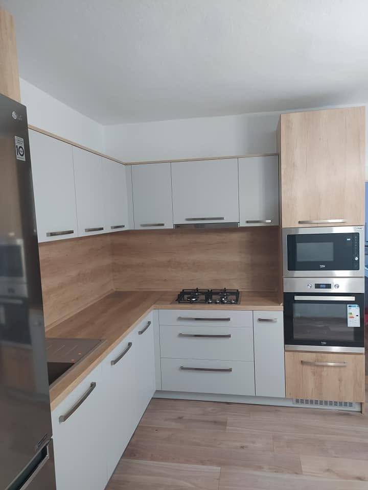 Weiße U-Küche mit hohem Eichendekor-Kasten und Kühlschrank