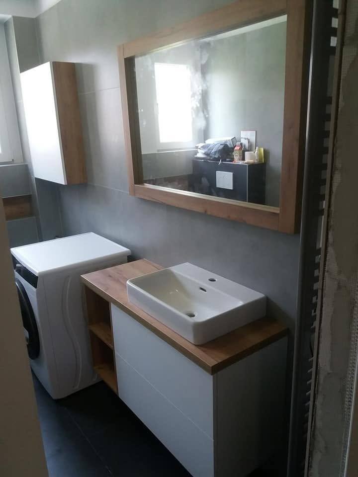 Weißer Schrank mit Eichenplatte und Spiegel bei der Waschmaschine