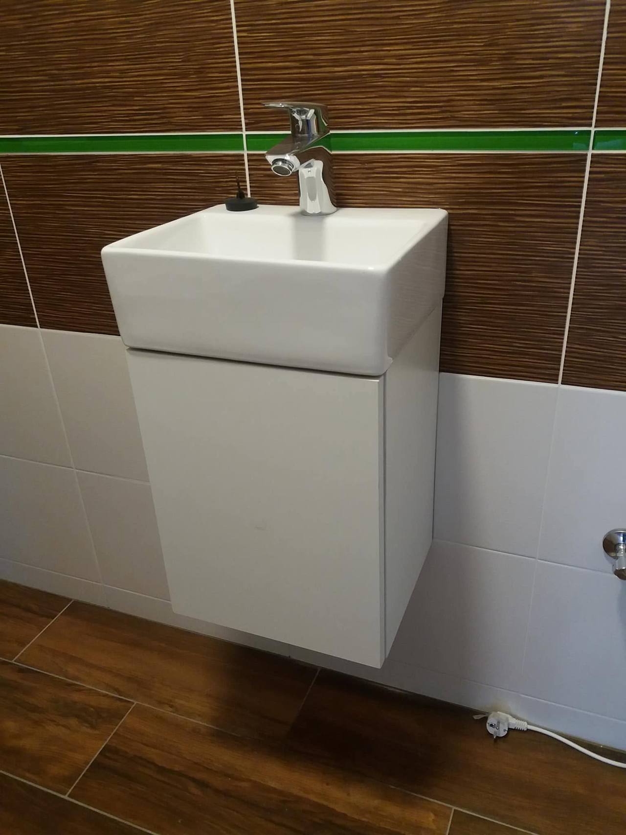 Kleiner weißer Hängeschrank mit Becken im separaten WC