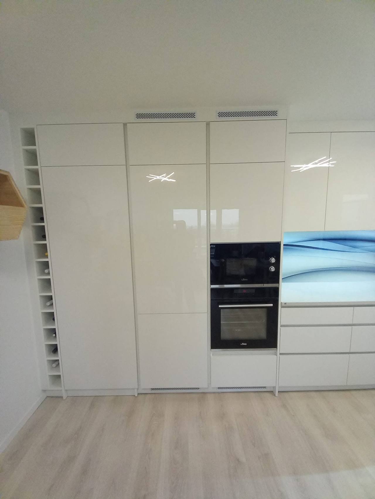 Hochschrankwand mit Einbaugeräten und schmalem Regal mit Fächern