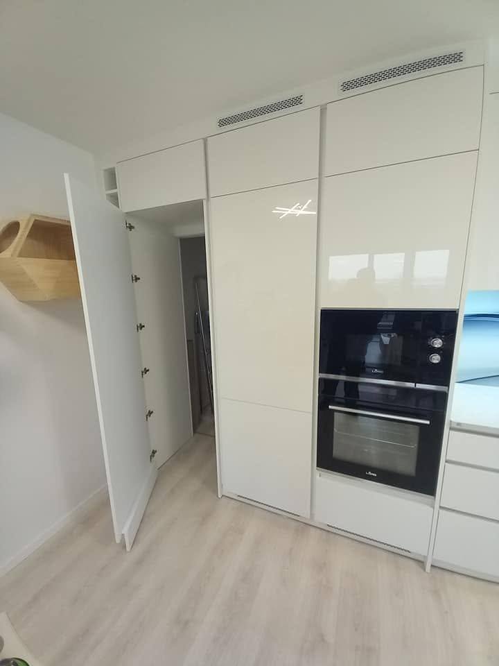 Geöffnete Tür in Schrankoptik neben dem Hochschrankblock
