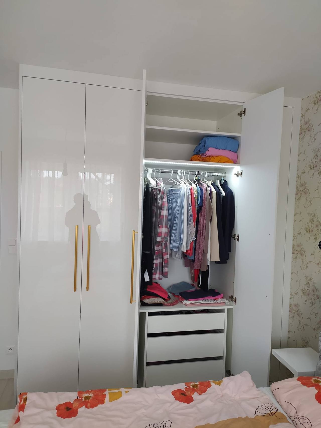Offener Hängebereich mit Kleidung und weißen Laden