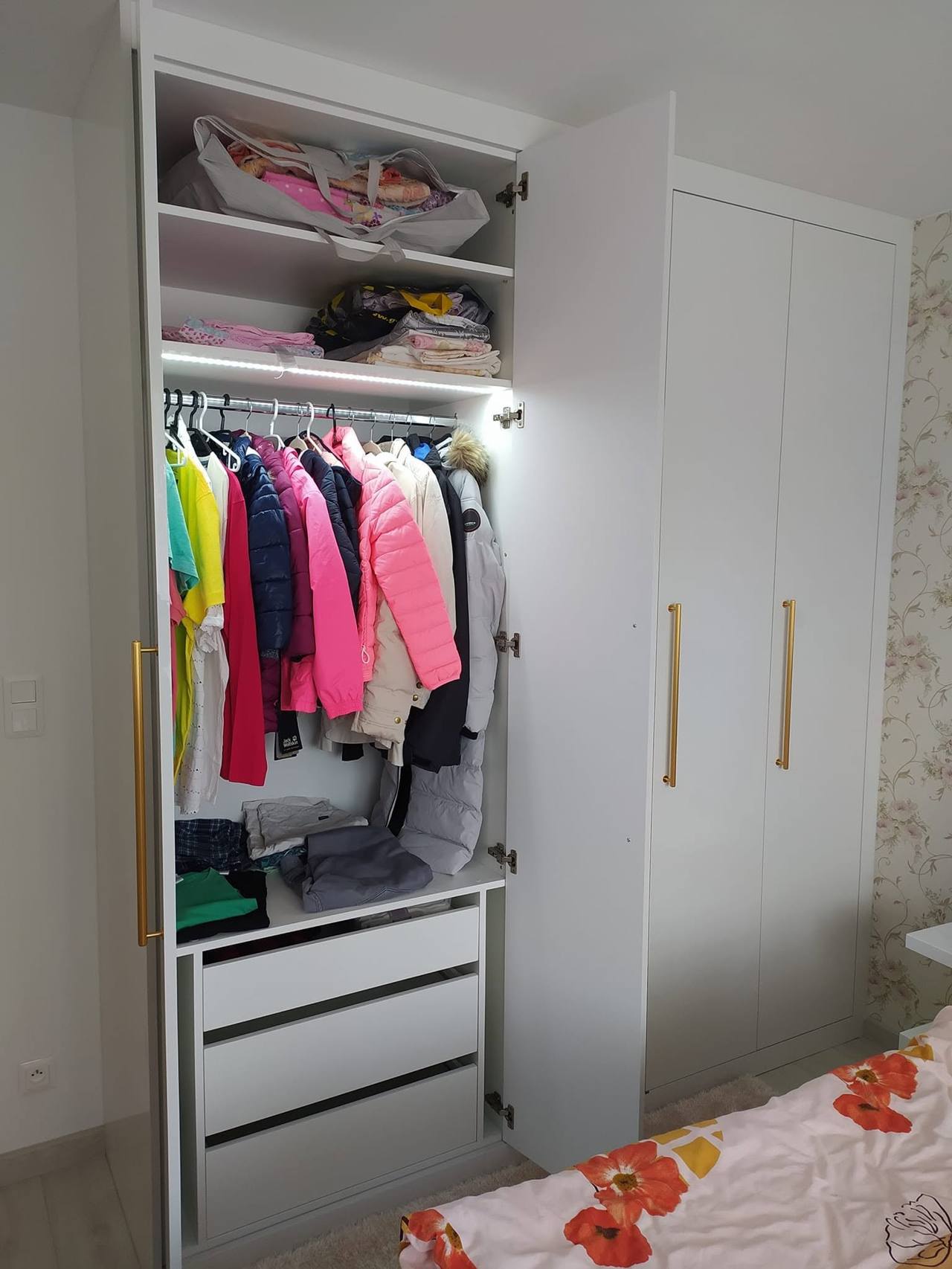 Beleuchtetes Innenleben mit Stange, Fachböden und Laden