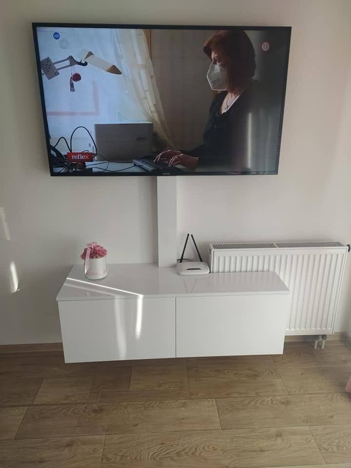 TV-Hängeelement mit zwei weißen Türen neben dem Heizkörper
