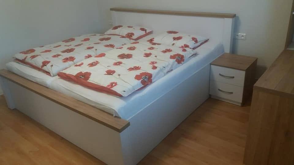 Weißes Doppelbett mit Eichen-Umrandung und Nachtkästchen