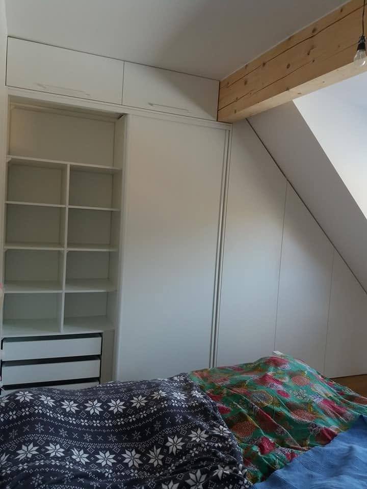 Weißer Kasten mit offenen Böden unter dem Dachbalken.