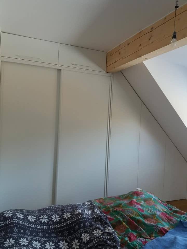 Schiebetüren des Einbaukastens unter den Holzbalken der Decke.