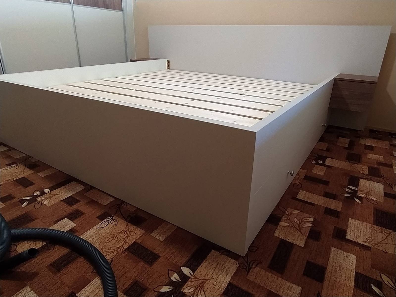 Biela posteľ s vysokým čelom a lamelovým roštom z nôh