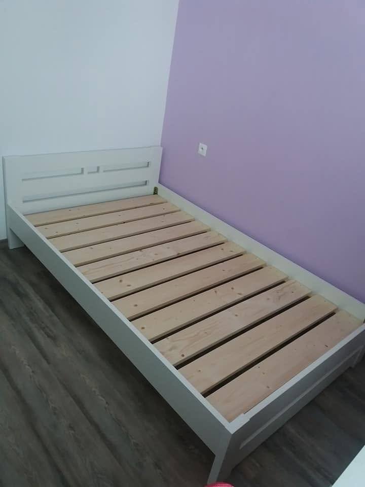 Weißes Doppelbett mit waagrechten Rillen im Kopfteil