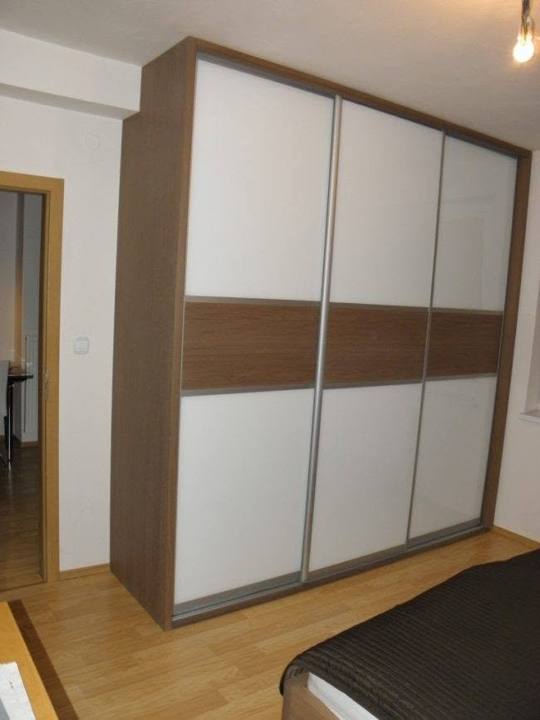 Weißer Schiebetürkasten mit Eichenband und Seitenwand im Schlafzimmer.
