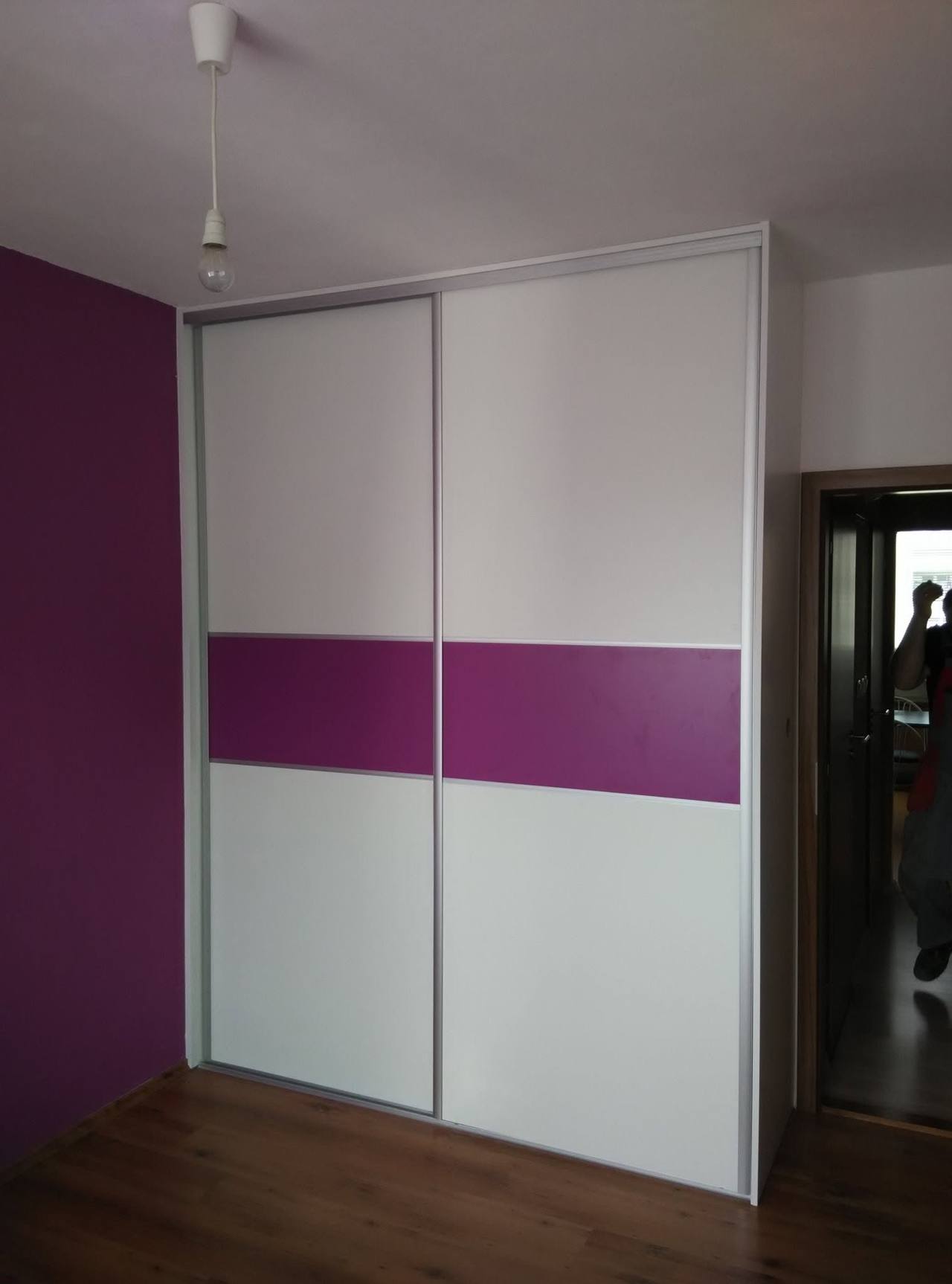 Dvojdverová biela skriňa s fialovým pásom vedľa vstupných dverí