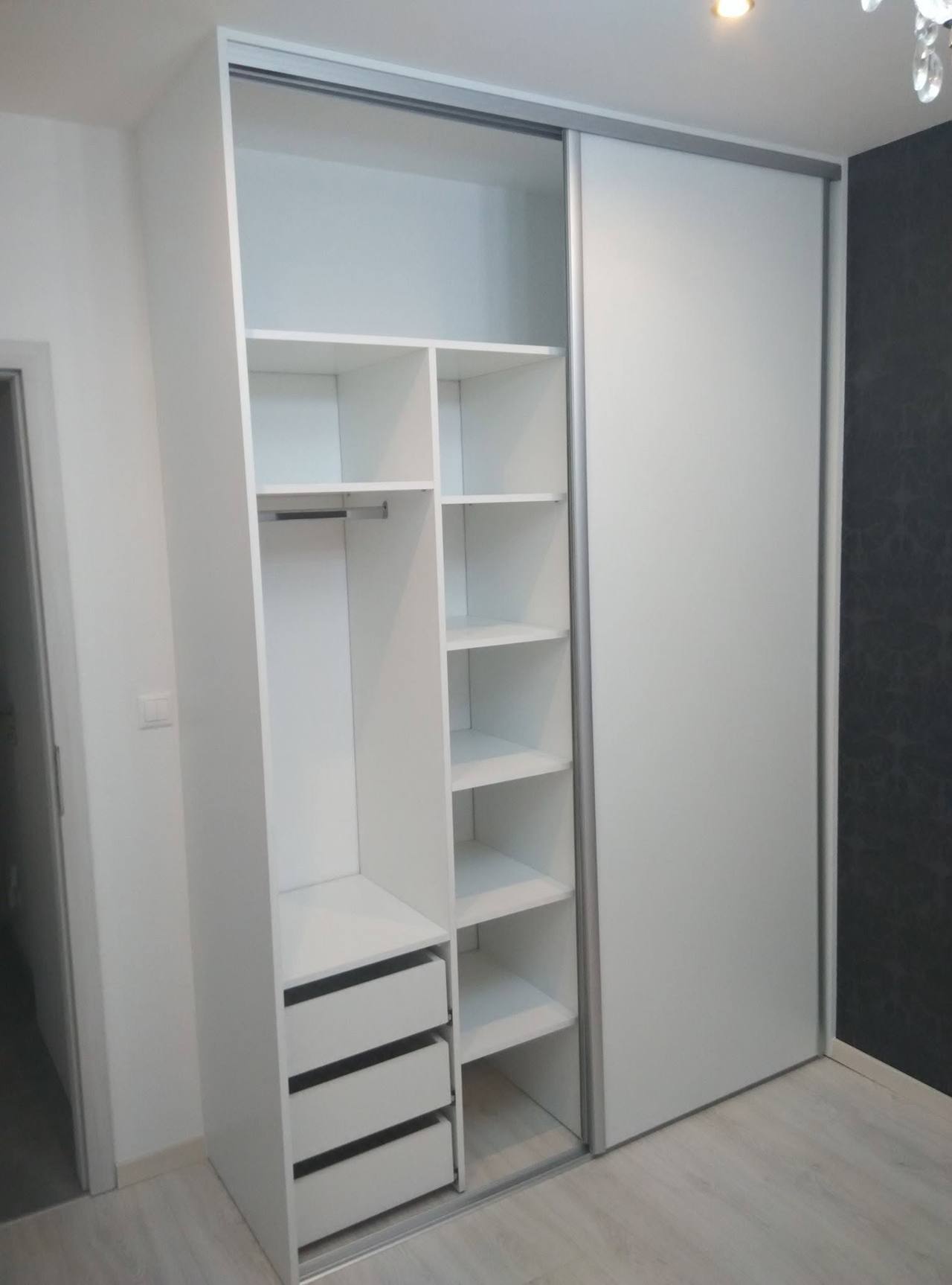 Offener weißer Kasten mit Fachböden, Stange und Laden unten