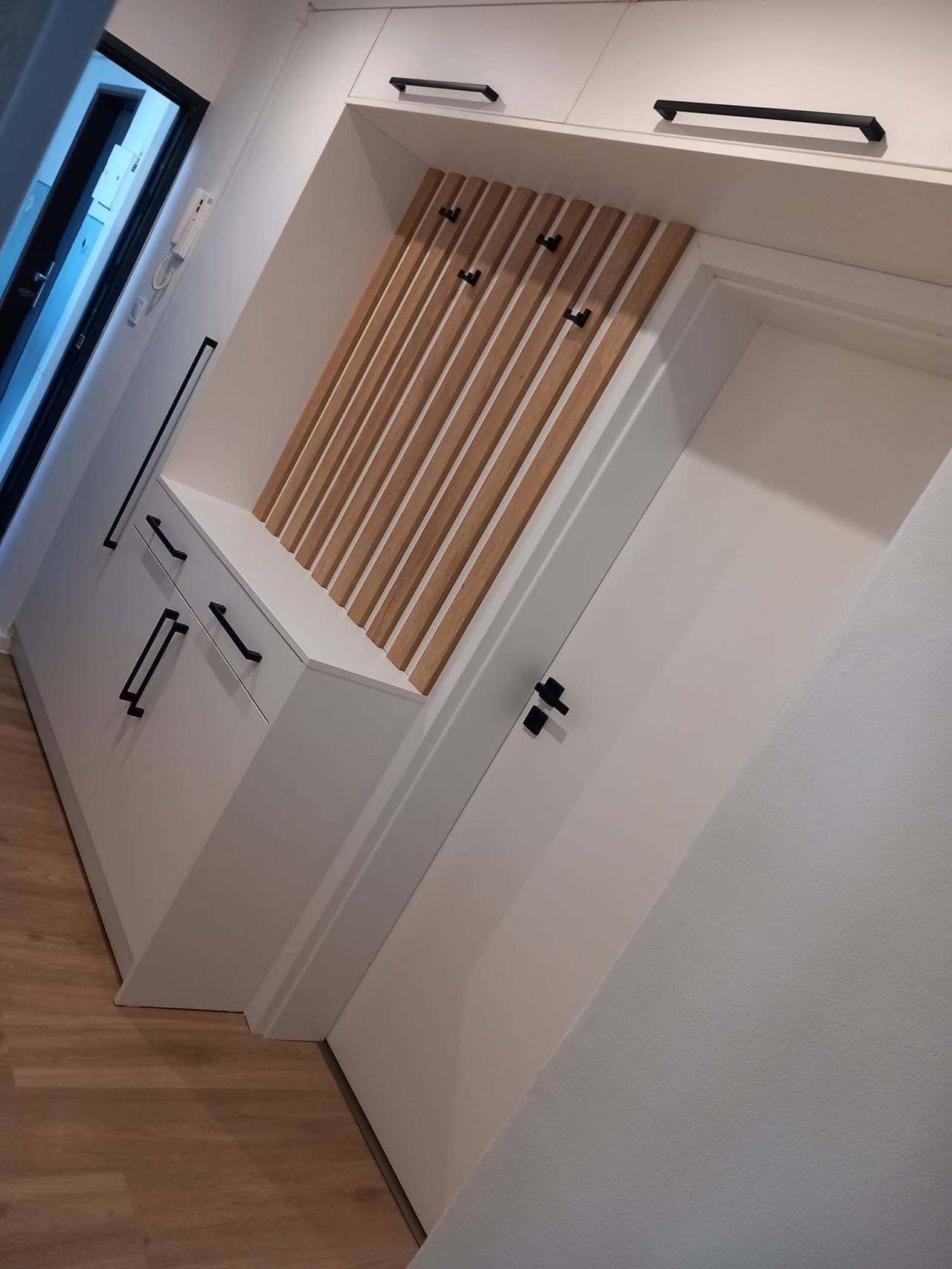 Blick von oben auf Lamellen mit Haken und Kästen über der Tür