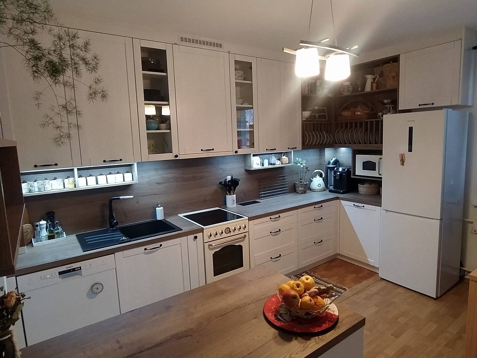 Landhausküche mit dunkler Rückwand, Vitrinen und LED-Licht