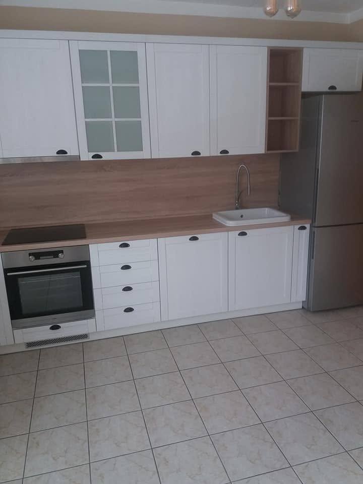 Weiße Rahmenzeile mit Backrohr, Abwasch und freistehendem Kühlschrank
