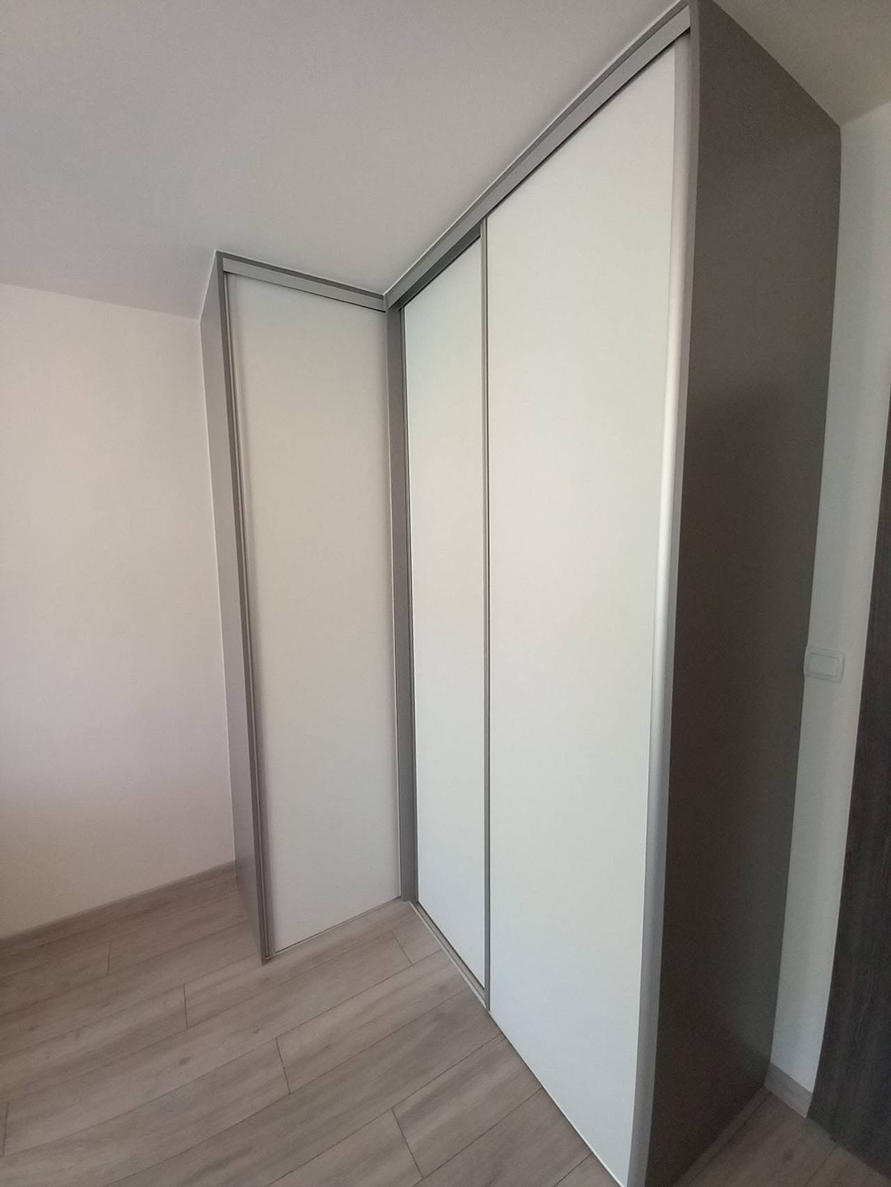 L-förmiger weißer Eckkasten in einem leeren Zimmer