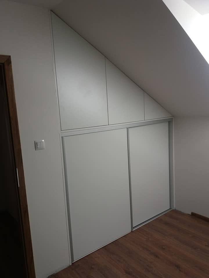 Weißer Kasten unter der Schräge neben der Zimmertür im Dachgeschoß