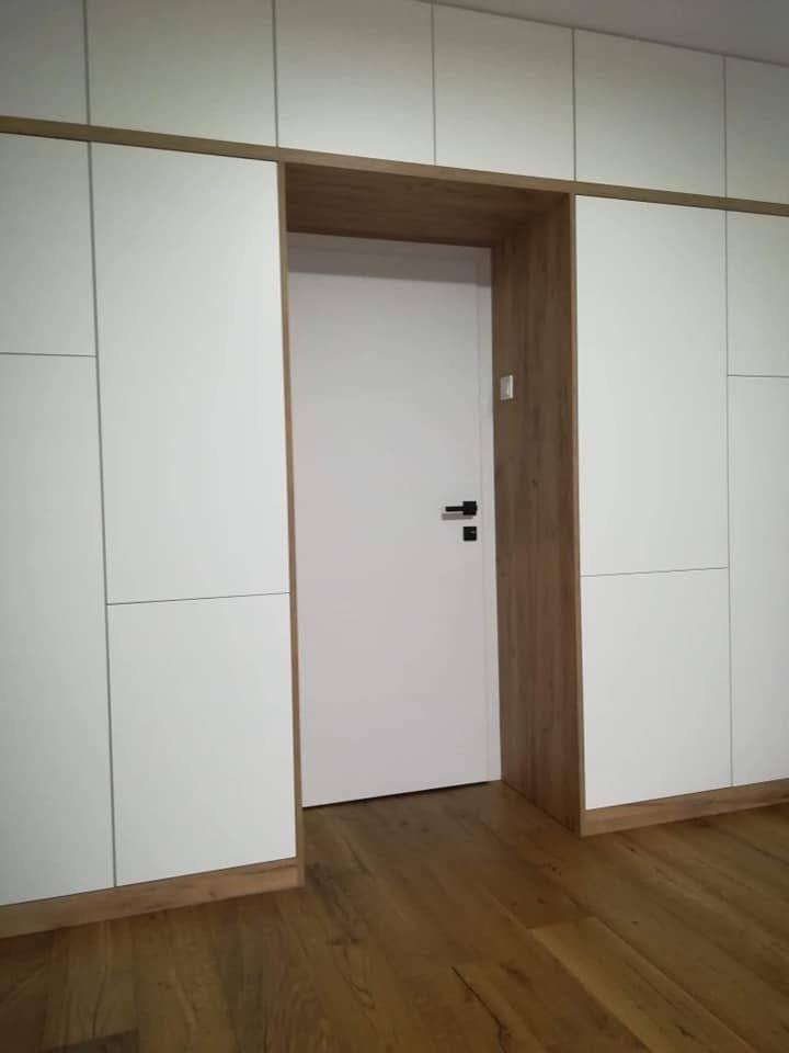 Weiße Stauwand mit eingebauter Tür im Eichenportal