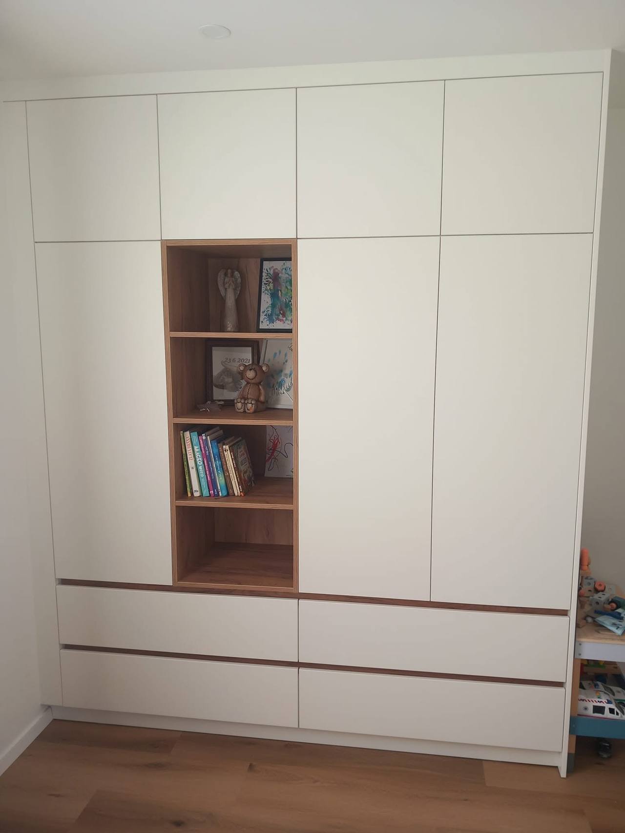 Biela skriňa po strop s knihami v orechovej nike