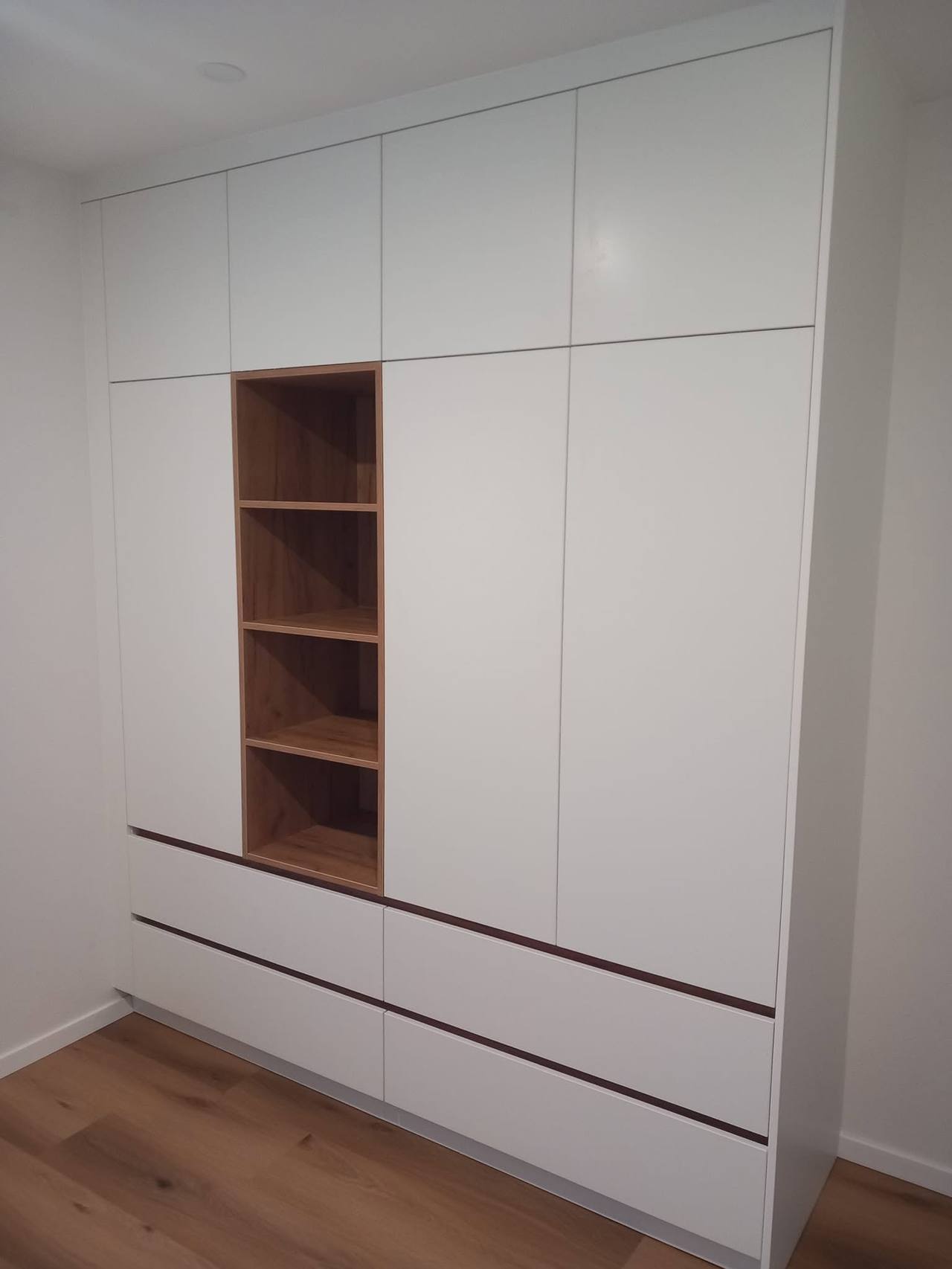 Bezúchytková biela skriňa s nikou a radom zásuviek