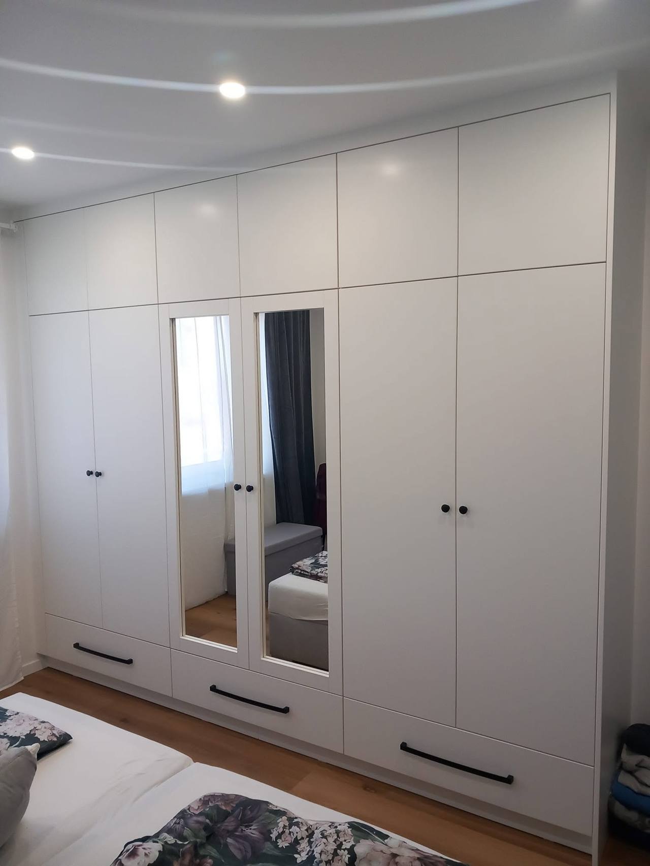 Weißer Kasten mit Aufsätzen und Spiegeltüren im Schlafzimmer