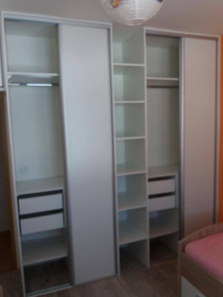 Geöffnete Kästen mit Kleiderstangen und weißen Laden