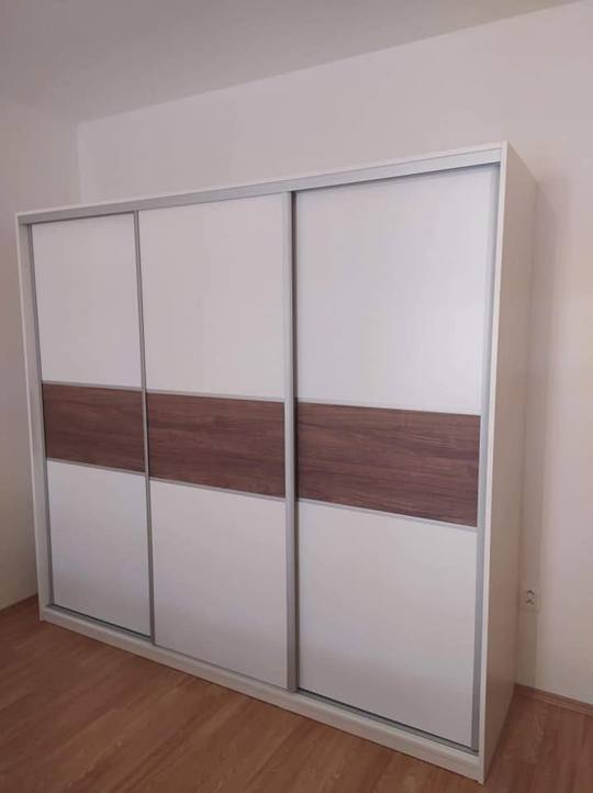 Weißer dreitüriger Schrank mit dunklem Querband